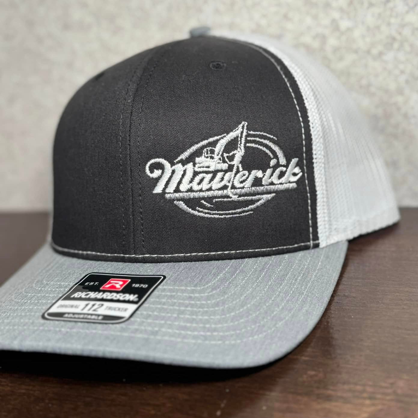 Black and gray cap with an embroidered logo on a wooden surface