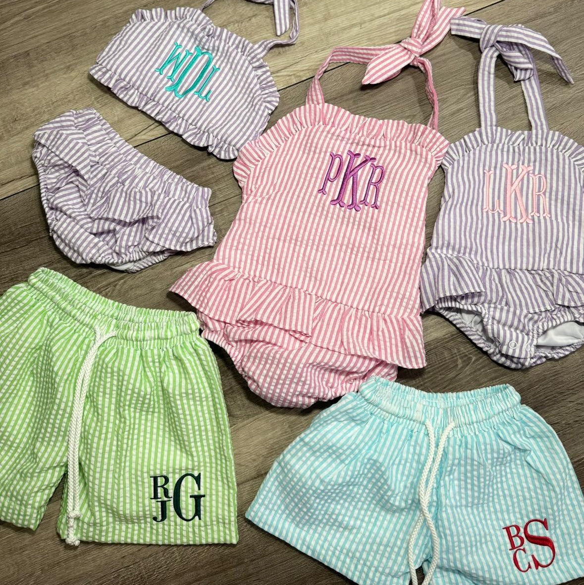 Children's swimwear set with embroidered monogramming on a wooden floor